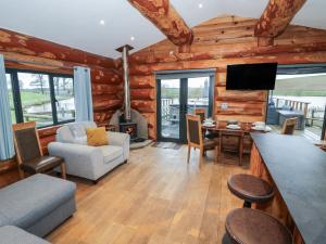 a living room with a fireplace in a log cabin at Cedar Cabin at Salford Court Farm Fishing Cabins in Worcester
