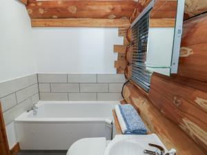 a bathroom with a tub and a toilet and a sink at Cedar Cabin at Salford Court Farm Fishing Cabins in Worcester +21 photos