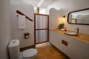 ein Badezimmer mit Toilette, Waschbecken und Spiegel in der Unterkunft Luna 6 in Mazunte