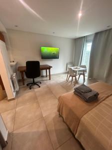 a bedroom with a bed and a desk and a table at Aires Almafuerte in Saladillo
