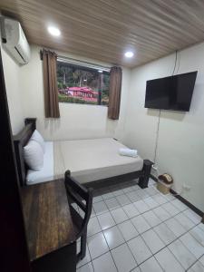 a room with a couch and a tv and a table at Hotel Don Fito in Golfito