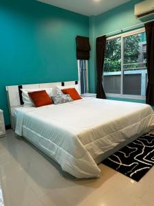 a large bed in a bedroom with a blue wall at Kamala cozy home in Kamala Beach