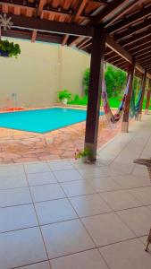 a pool with a hammock next to a house at Pousada luz do Sol in Cacoal