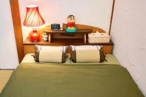 a bedroom with a bed and a table with a lamp at ラベンダー畑まで5分ー最大10人ーお餅つきー流しそうめんー花火ー五右衛門風呂ー心と身体が元気になる古民家民泊ーオモテナシロッジ悠遊 in Nakafurano