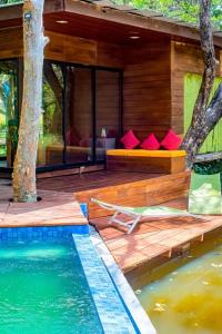 a house with red pillows on a deck next to a pool at Harmony by the lake in Dambulla