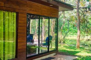 a glass house with a view of the woods at Harmony by the lake in Dambulla +21 photos