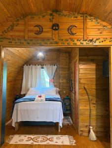 a bedroom with a bed in a wooden cabin at Cabana Rota do Vinho in São Roque