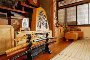 a room with a bench and a painting on the wall at ラベンダー畑まで5分ー最大10人ーお餅つきー流しそうめんー花火ー五右衛門風呂ー心と身体が元気になる古民家民泊ーオモテナシロッジ悠遊 in Nakafurano