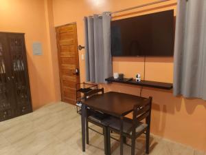 a dining room with a table and a television on a wall at Orange House in San Juan +13 photos