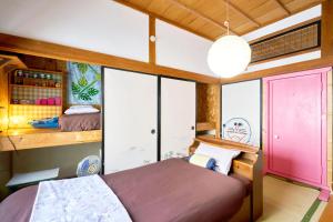 a bedroom with a large bed and a pink door at ラベンダー畑まで5分ー最大10人ーお餅つきー流しそうめんー花火ー五右衛門風呂ー心と身体が元気になる古民家民泊ーオモテナシロッジ悠遊 in Nakafurano