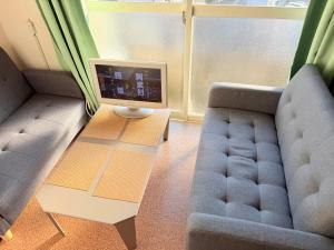 a living room with a couch and a computer on a table at ハイツ清水103 in Nagasaki