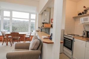 a kitchen with a couch and a table with a dining room at 1 Hazeldene in Salcombe