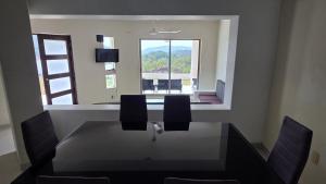 a dining room with a table and chairs and a window at Casa Chaue in Tangolunda