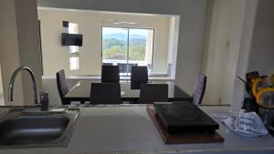 a kitchen with a sink and a table with chairs at Casa Chaue in Tangolunda