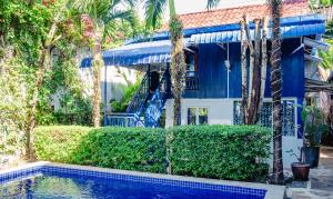 a house with a swimming pool and palm trees at Villa Blue Lagoon in Sihanoukville