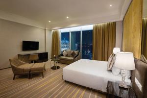 a hotel room with a bed and a living room at Dorsett Putrajaya in Putrajaya