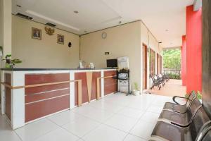 a kitchen with a counter and chairs in a room at Wisma Belerang Kalianda Lampung RedPartner in Kalianda