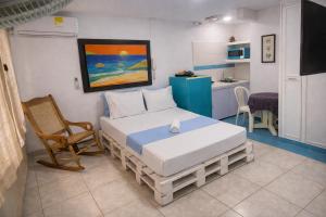 a bedroom with a bed and a chair in it at QuillaHost Guesthouse in Barranquilla