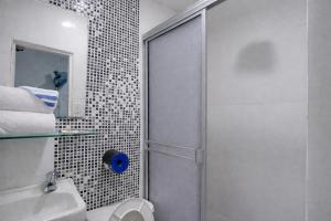 a bathroom with a shower and a toilet and a sink at QuillaHost Guesthouse in Barranquilla +54 photos