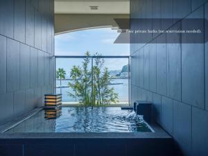 a swimming pool in a building with a view of the water at La Vista Atami Terrace in Atami