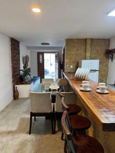 a kitchen with a large wooden counter and chairs at Casa Aura Solis Preá in Prea