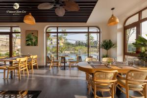 a restaurant with tables and chairs and windows at Pataco Tam Coc Hotel in Vũ Lâm