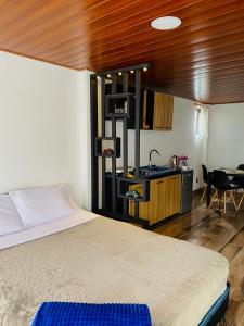 a bedroom with a bed and a kitchen and a table at Loft Del Ruiz - Apartamentos in Líbano