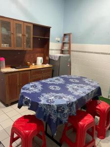 a kitchen with a table and four red stools at VJ Homestay in Jasin