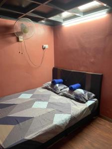 a bed in a room with a fan at VJ Homestay in Jasin +4 photos