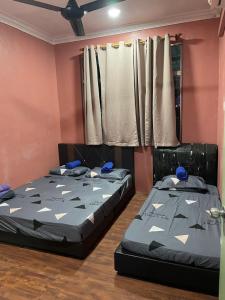 two beds sitting in a room with at VJ Homestay in Jasin