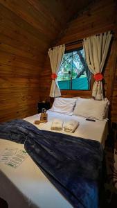 a bedroom with a large bed with a window at Cabana Rota do Vinho in São Roque