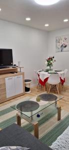 a living room with a table and a tv at Šiauliai Central Vytauto Apartment in Šiauliai