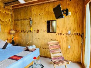 a room with a bed and a wooden wall at Suites Costa Madéro - Punta Zicatela in Brisas de Zicatela