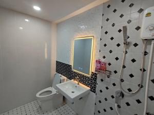a bathroom with a white toilet and a sink at Dolce Home suratthani in Suratthani +18 photos