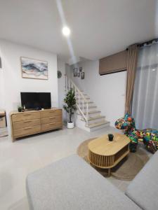 a living room with a couch and a table at Dolce Home suratthani in Suratthani