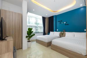 a bedroom with two beds and a tv in it at E Stay Boutique in Vung Tau