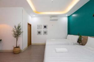 a bedroom with two beds and a green wall at E Stay Boutique in Vung Tau