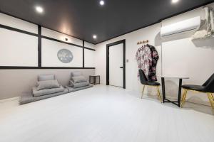 a living room with a couch and a chair at Ryokan Stay in Gangneung