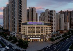 a large building with a sign on it in a city at Mercure Wuhan Yangluo in Wuhan