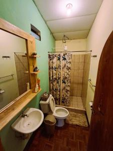 a bathroom with a sink and a toilet and a shower at Casa Cacao in Lanquín