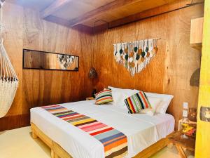 a bed in a room with a wooden wall at Suites Costa Madéro - Punta Zicatela in Brisas de Zicatela +66 photos