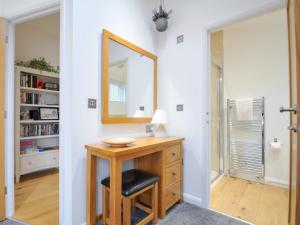 a bathroom with a vanity with a mirror and a stool at 15 Faraway Fields in Liskeard +41 photos