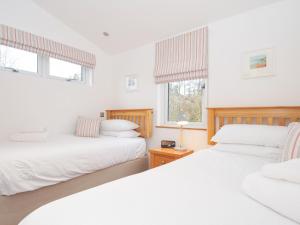 two beds in a room with two windows at 15 Faraway Fields in Liskeard