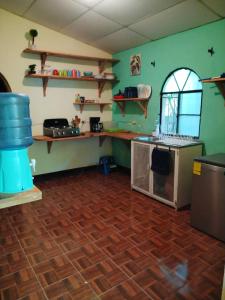 a kitchen with green walls and a wooden floor at Casa Cacao in Lanquín +6 photos