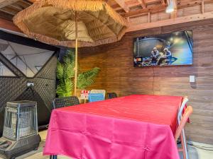 a room with a table and a tv on a wall at 海宿ニシノヤ in Shioya