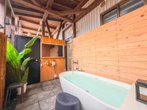 a bathroom with a blue tub in a wooden wall at 海宿ニシノヤ in Shioya +71 photos