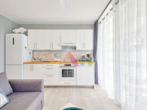 a kitchen with white cabinets and a white refrigerator at Studio à Anse Marcel - FR-1-734-86 in Marigot