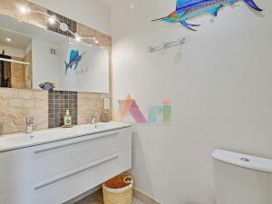 a bathroom with a sink and a mirror and a toilet at Studio à Anse Marcel - FR-1-734-86 in Marigot +20 photos