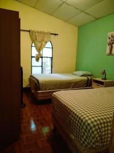 a room with two beds and a window at Casa Cacao in Lanquín