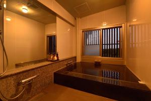 a bathroom with a bath tub and a sink at Business Resort Kyuan in Oita +45 photos
